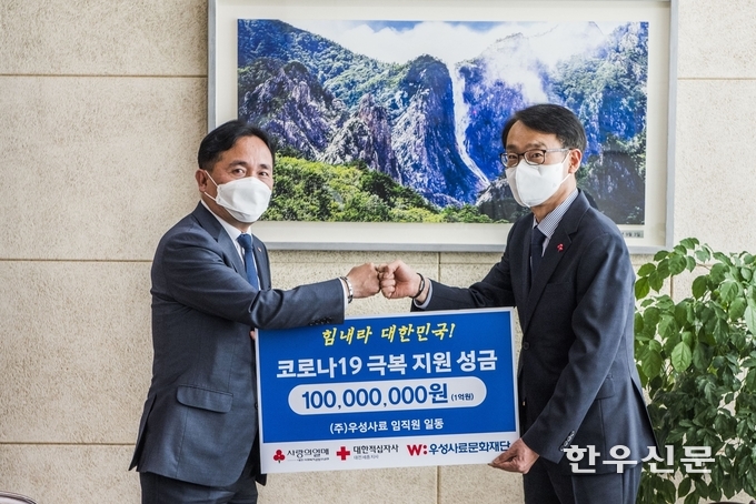 우성사료 한재규 대표이사(왼쪽)가 TJB대전방송 이광축 사장에게 성금을 전달하며 코로나19 극복 기원을 다짐하고 있다.