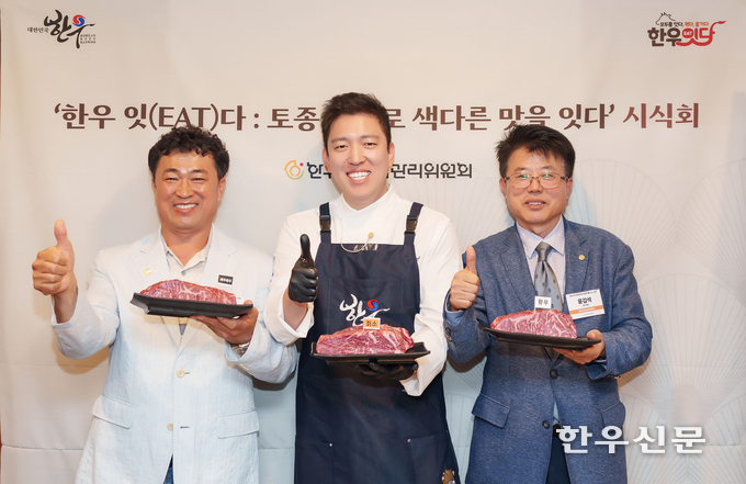 한기웅 한우자조금 부위원장(왼쪽부터), 김호윤 셰프, 윤갑석 한우자조금 사무국장이 한우를 들고 포즈를 취하고 있다.